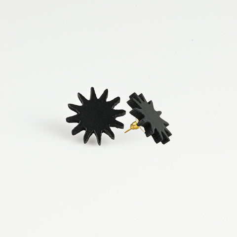 A pair of black starburst stud earrings with gold-tone posts, shown on a clean white background.