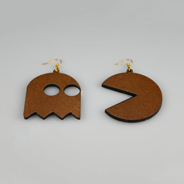 A pair of wooden dangle earrings shaped like a ghost and a Pac-Man style mouth, shown on a plain light gray background.