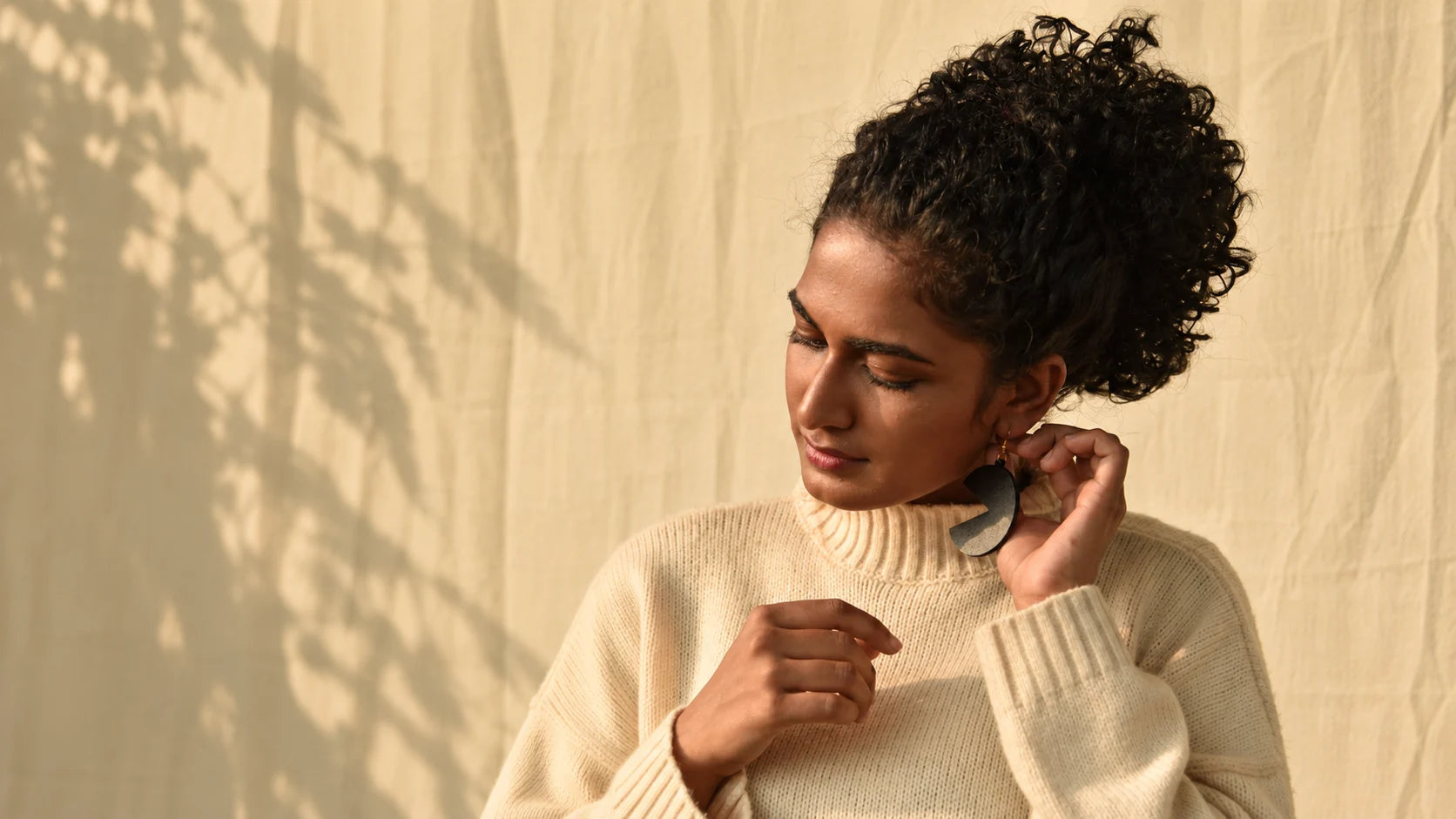 Model wearing AD’NOVEL handcrafted wooden earrings in warm sunlight